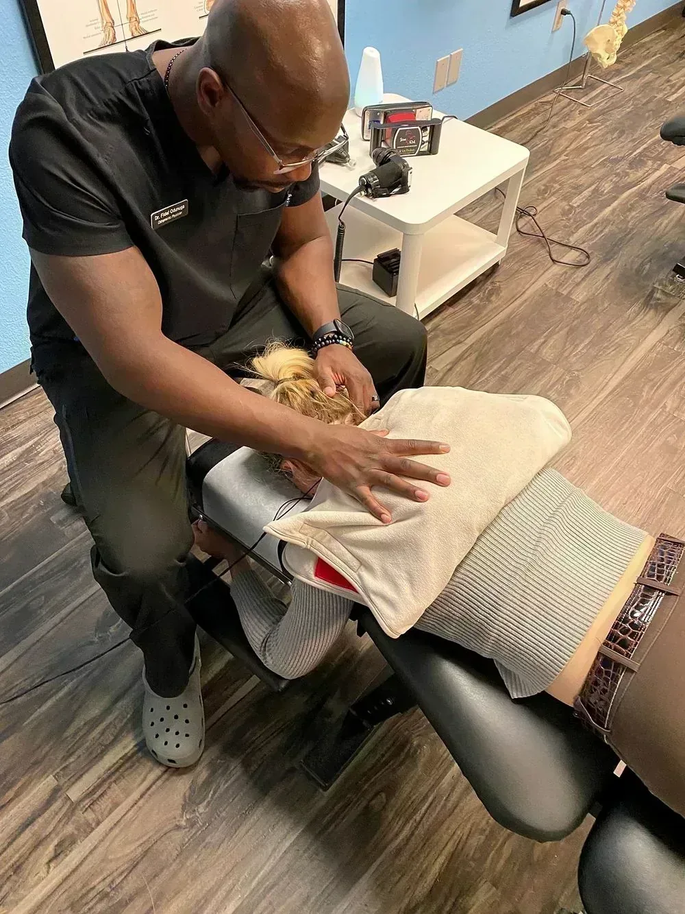 Dr. Odunuga performing a cervical adjustment on a patient at the clinic