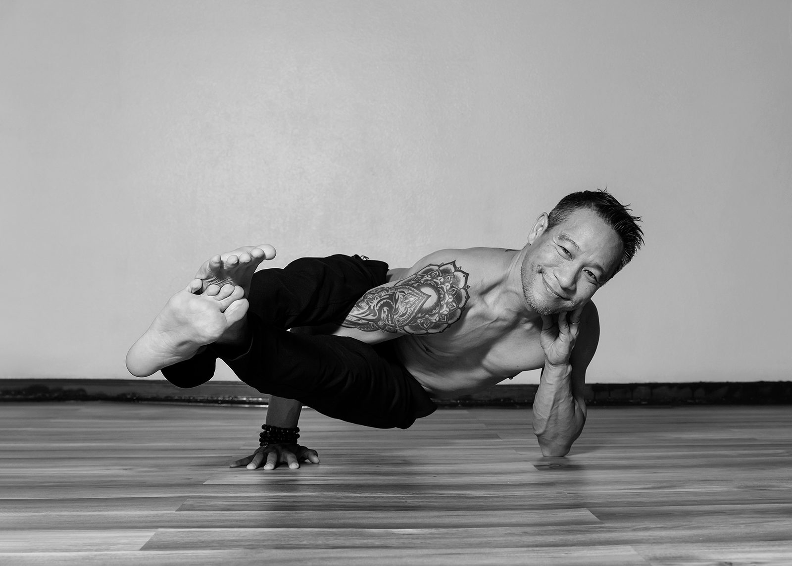 A student holding a one-legged arm balance, black and white studio portrait